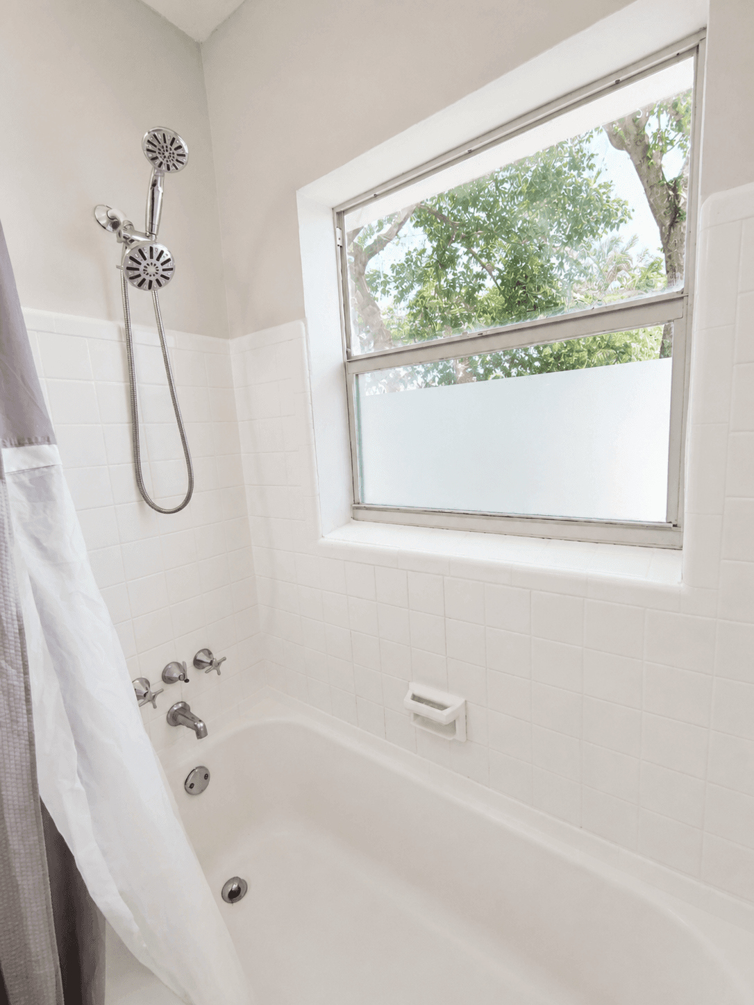 Bathtub with dual showerhead and frosted window for natural light