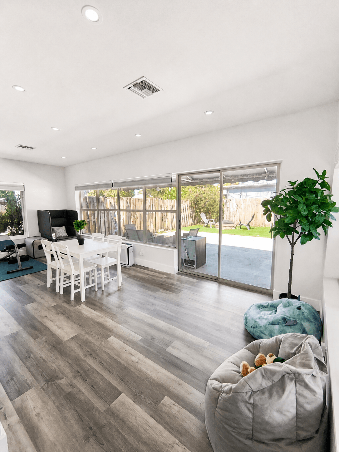 Sunroom dining for four with backyard views and a small fitness corner