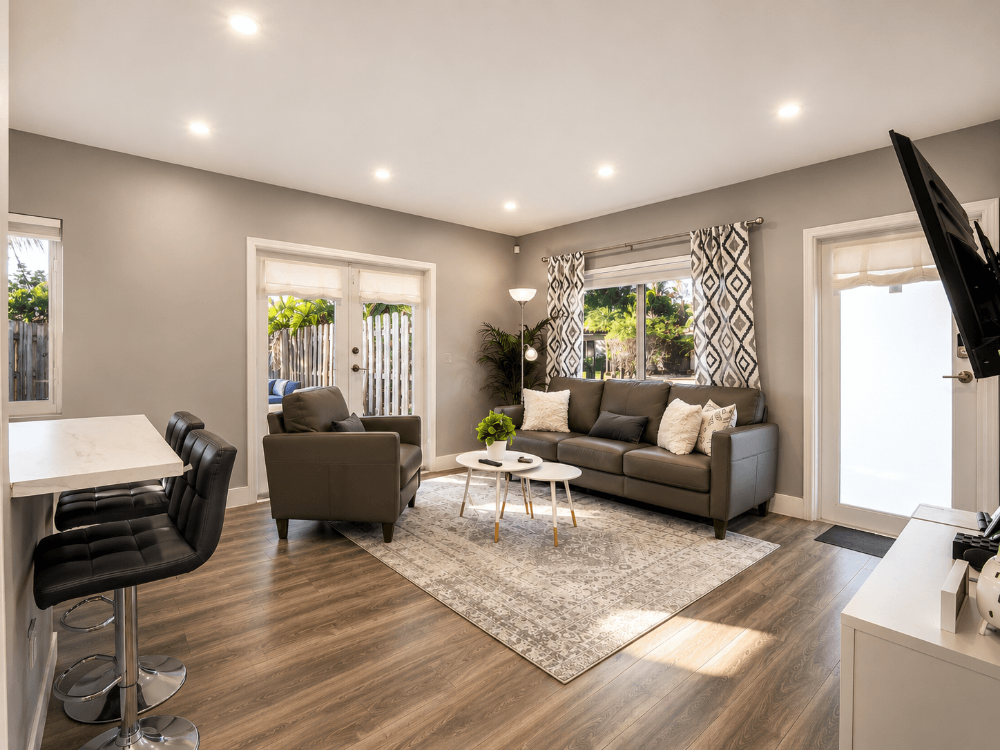 Living room with grey leather seating and breakfast bar