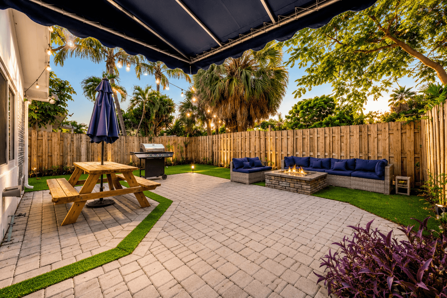 Outdoor patio at dusk with fire pit and string lights
