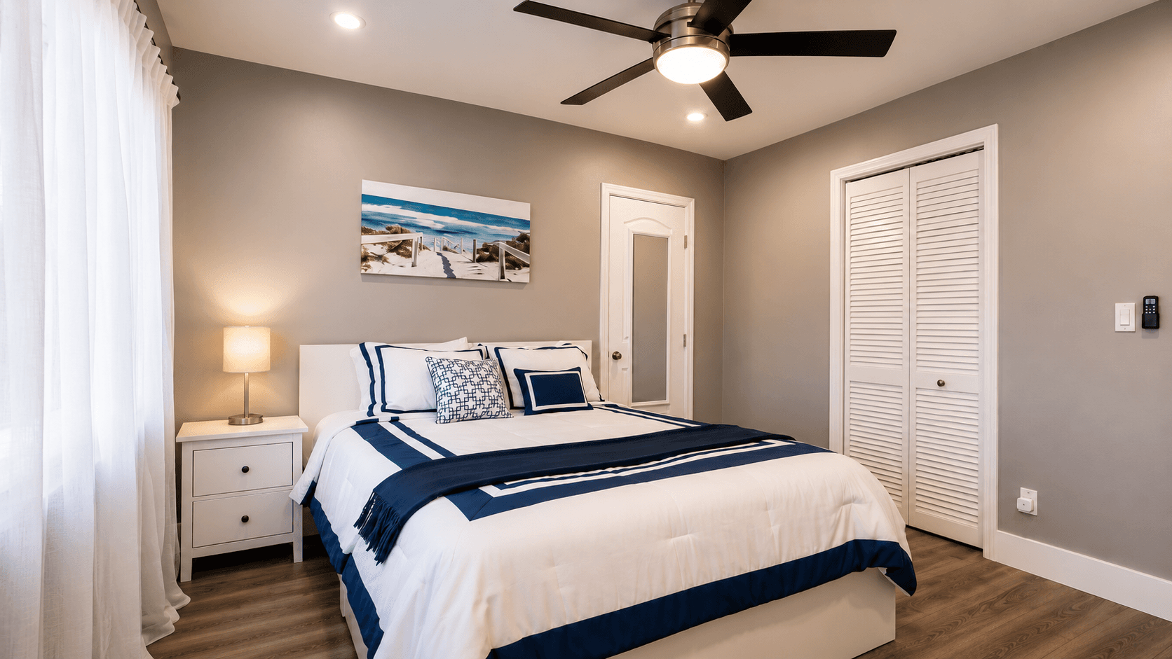 Primary suite detail with coastal bedding and beach art