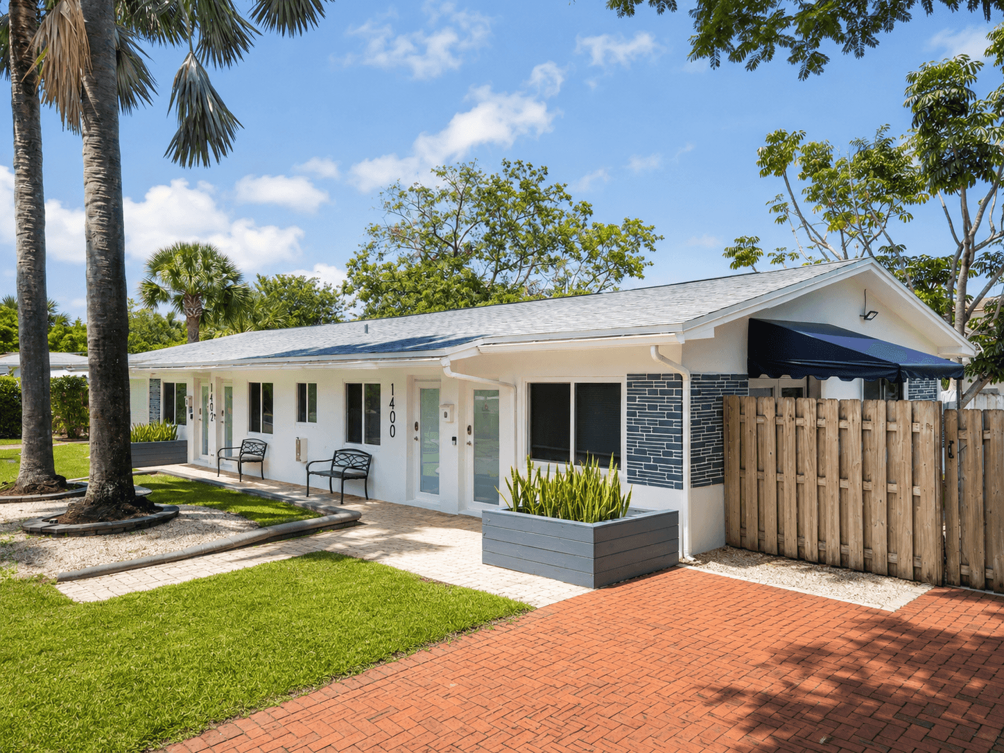 Poinsettia Paradise exterior with brick entry, planters, and palm trees